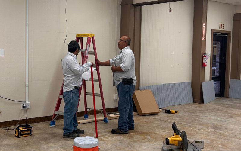 SWTJC工作人员Jose De la Cruz和Alejandro Gomez正在改造Uvalde校区新扩建的学生休息室.